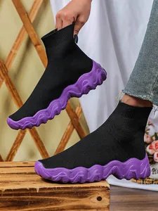 Gedetailleerd overzicht van zwarte fly-knit sok-sneakers voor dames met paarse zool