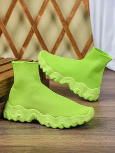 Gedetailleerd overzicht van neongroene gebreide sok-schoenen met dikke zool.