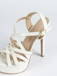Close-up detail of white platform high heel sandal with cross straps