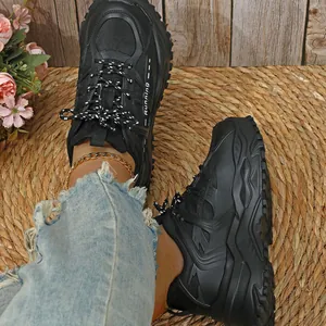 Dikke zwarte plateau sneakers aan de voet met ademende mesh en dikke zool details