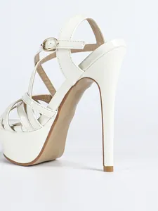 Close-up of white platform stiletto sandals featuring elegant cross strap detail