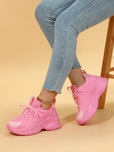 Vue détaillée de baskets compensées roses avec semelles à plateforme sur un modèle