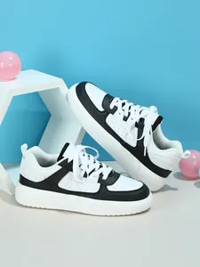 Primer plano de zapatillas con plataforma blancas y negras con cordones y agujeros transpirables.
