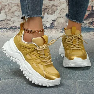 Gedetailleerd overzicht van gele chunky sneakers met dikke witte zool en gouden trim