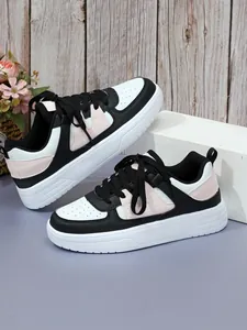 Vista detallada de zapatillas de plataforma con bloques de color negro, blanco y rosa.