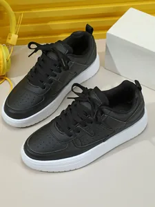 Vista detallada de zapatillas casuales negras con suela blanca gruesa y cordones
