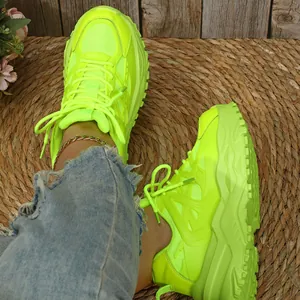 Detailopname van neongele platform sneakers met ademend mesh en dikke zool.