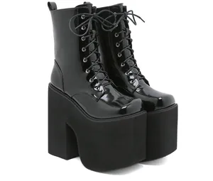 Side view detail of black patent leather boots with extreme platform and chunky heels.