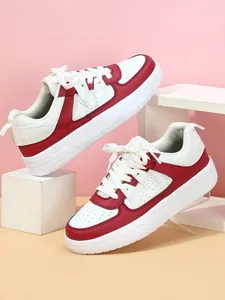 Detalle de cerca de zapatillas informales rojas y blancas con suela gruesa y cordones