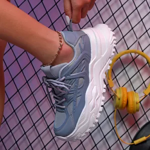 Detailweergave van een grijze chunky platform sneaker met ademend mesh en dikke witte zool.