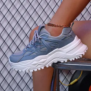 Close-up van stijlvolle grijze ademende platform sneakers met dikke witte zolen