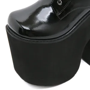 Detailed macro view of black patent leather platform boots with thick matte sole