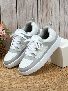 Primer plano de zapatillas con plataforma grises y blancas con diseño de cordones