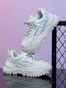 Detailweergave van witte chunky platform sneakers met ademend mesh en dikke zolen