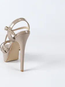 Detailed view of nude patent leather stiletto heel and platform sandals for parties