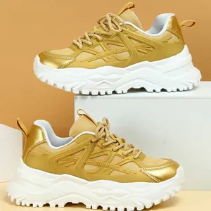 Zijprofiel van gouden chunky sneakers met ademend mesh en dikke witte platformzolen
