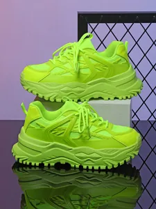 Gedetailleerd zijaanzicht van neongroene chunky sneakers met dikke ademende zolen.
