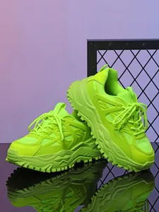 Gedetailleerd overzicht van neongroene chunky platform sneakers met ademend mesh