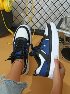 Primer plano de zapatillas color-block con suela gruesa en un moderno entorno urbano