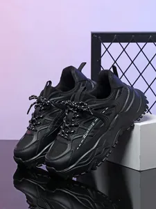 Gedetailleerd overzicht van zwarte chunky sneakers met dikke zolen en ademend mesh.
