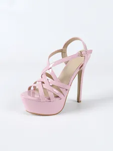 Detailed side view of pink patent leather platform stiletto sandals with cross straps.
