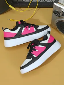 Vista superior dinámica de zapatillas de plataforma rosas y negras con objetos vintage