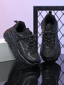 Detailopname van zwarte chunky sneakers met ademend mesh en dikke zolen voor buiten.