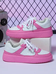 Vista detallada de zapatillas de deporte de plataforma rosa y blanca en un pedestal