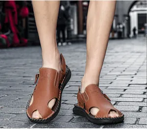 Primer plano de sandalias de cuero marrón para hombre con diseño lateral hueco y puntera