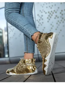 Detailed view of gold glitter high-top sneakers with unique octopus wavy soles worn on feet