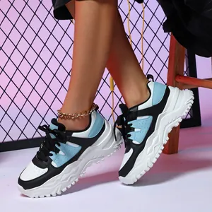 Breathable chunky platform sneakers featuring blue and black color-block design on street background