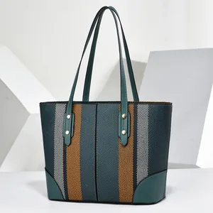 Front view of large capacity striped tote bag with teal leather handles and accents