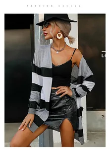 Chic model wearing a grey and black striped cardigan paired with a faux leather skirt.