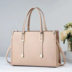 Vista lateral de un bolso tote beige de piel texturizada con elegantes detalles dorados.