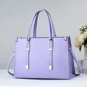 Primer plano del bolso lavanda con detalles dorados y textura de cuero granulado