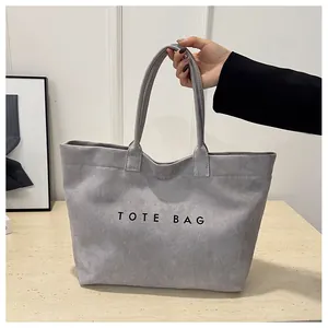 Gros plan d'un sac cabas en daim gris vintage avec imprimé lettres et grande capacité