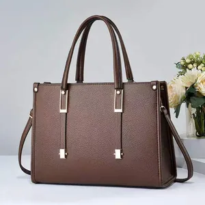 Vista frontal del bolso de cuero granulado marrón con elegantes detalles metálicos dorados