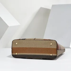 Detailed bottom view of striped fabric tote bag featuring protective gold metal feet