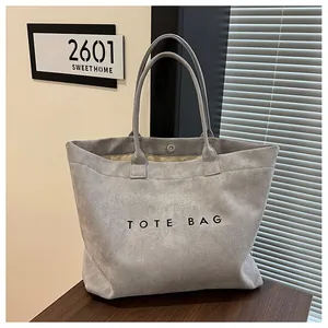 Vue détaillée d'un sac cabas en daim gris rétro avec broderie dans un décor de style de vie