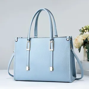 Bolso de mano en cuero azul claro texturizado con herrajes dorados y correa larga