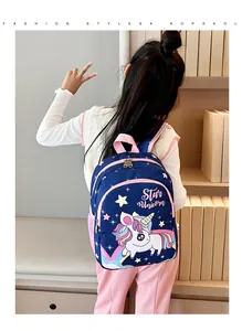 Jeune fille portant un sac à dos licorne bleu marine dans un cadre de vie chaleureux.