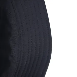 Close-up detail of black cotton bucket hat showing reinforced brim stitching texture.