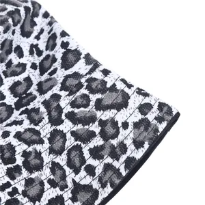 Detailopname van een luipaardprint vissershoed met stoftextuur en stiksels op de rand