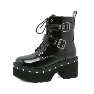 Détail de la bottine de combat à plateforme en cuir verni noir avec boucles et clous.
