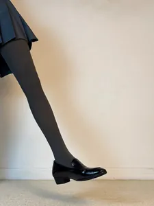 Elegant close-up of black patent leather loafers with chunky low heels in French style