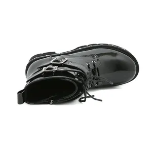 Vue détaillée de bottines en cuir verni noir avec boucles et clous argentés