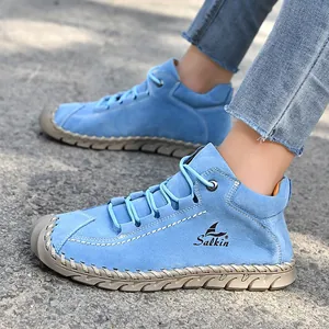 Close-up side view of blue hand-stitched outdoor casual loafers for women on street