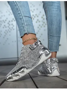 Detail view of silver glitter high-top sneakers with metallic panels and octopus sole.