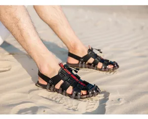 Men's breathable black leather fisherman sandals shown on a sandy beach outdoor lifestyle