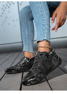Detailed view of fashionable black glitter high-top boots with wave-shaped rubber soles
